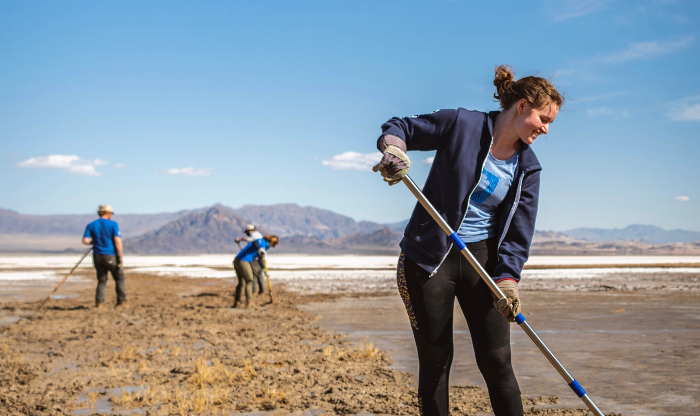 SCA Mojave Desert Restoration Crew Member raking dirt in the Mojave desert